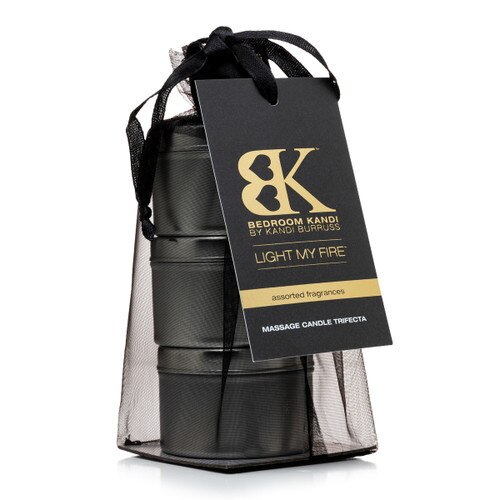 An image of three small massage oil candle tins stacked on top of each other in a black organza bag. A tag attached to the bag reads "Light My Fire" and Assorted Fragrances.